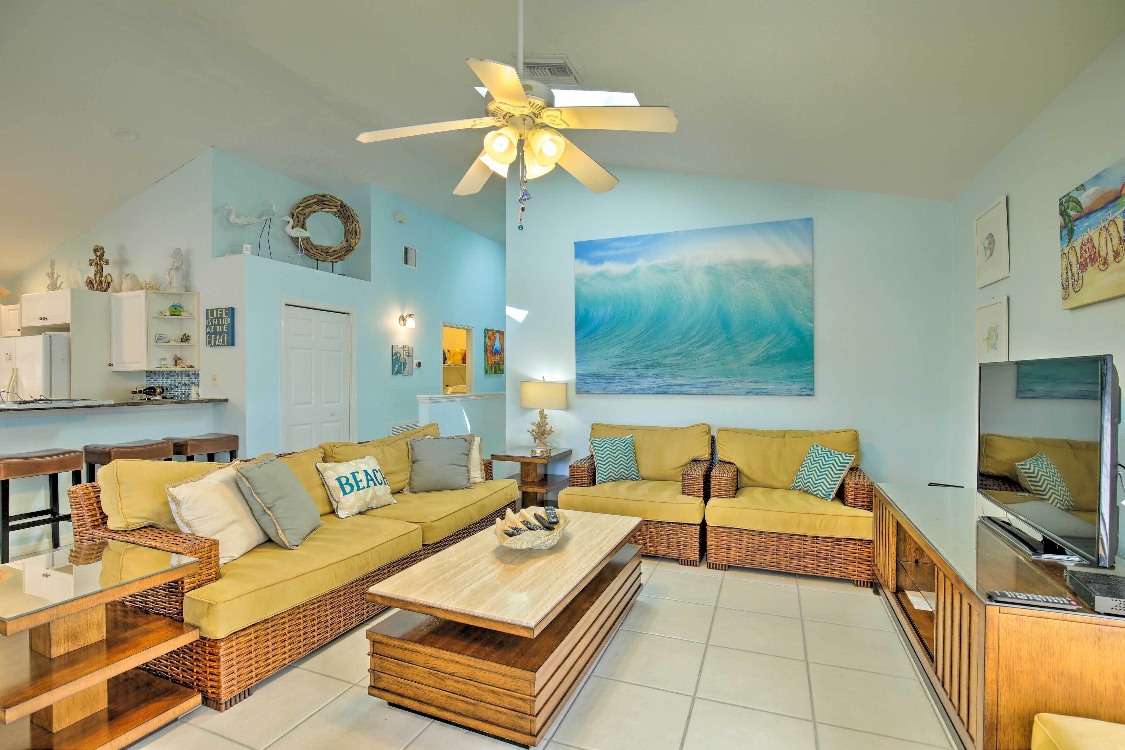 A living room with a large sofa set, a coffee table, and a ceiling fan.
