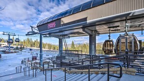 Une station de télésiège dotée d’une zone d’attente abritée, d’un panneau indiquant « Breck Connect Gondola », et offrant une vue sur le paysage enneigé environnant.
