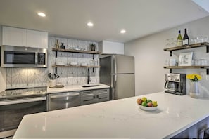 A modern kitchen with stainless steel appliances, a marble countertop, and a built-in oven. - Walk to Main St & Ski Lift: Breck Condo w/ Pool! (Breckenridge)