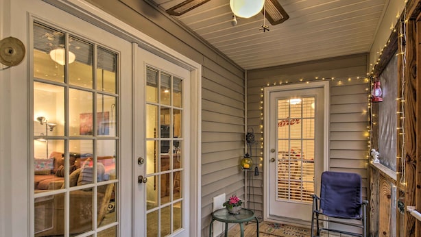 A cozy porch with a red rug, a small table with a potted plant, and a chair. - Chapin Home Near Boat Launch & Lake Murray! (Chapin)