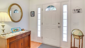 A hallway with a wooden dresser, a mirror, a globe on a stand, and a door with a window. - Chapin Home Near Boat Launch & Lake Murray! (Chapin)