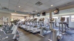 A gym with multiple treadmills, ellipticals, and weight machines.