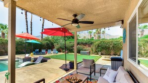 A covered patio area with a pool, outdoor furniture, and umbrellas. - Private Pool & Putting Green: Palm Springs Home! (Palm Springs)