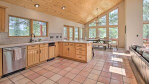 Eine geräumige Küche mit Holzausstattung, großen Fenstern und einer Terrasse mit Sitzgelegenheiten.