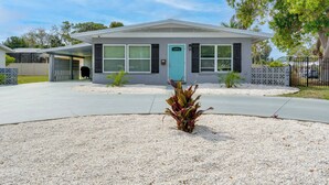 A single-story house with a teal door, a covered porch, and a small garden area with gravel and plants. - Bright Venice Getaway < 1 Mi to Historic Dtwn (Venice)