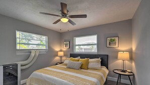 A bedroom with a bed, two bedside tables, a ceiling fan, and two windows with blinds. - Bright Venice Getaway < 1 Mi to Historic Dtwn (Venice)