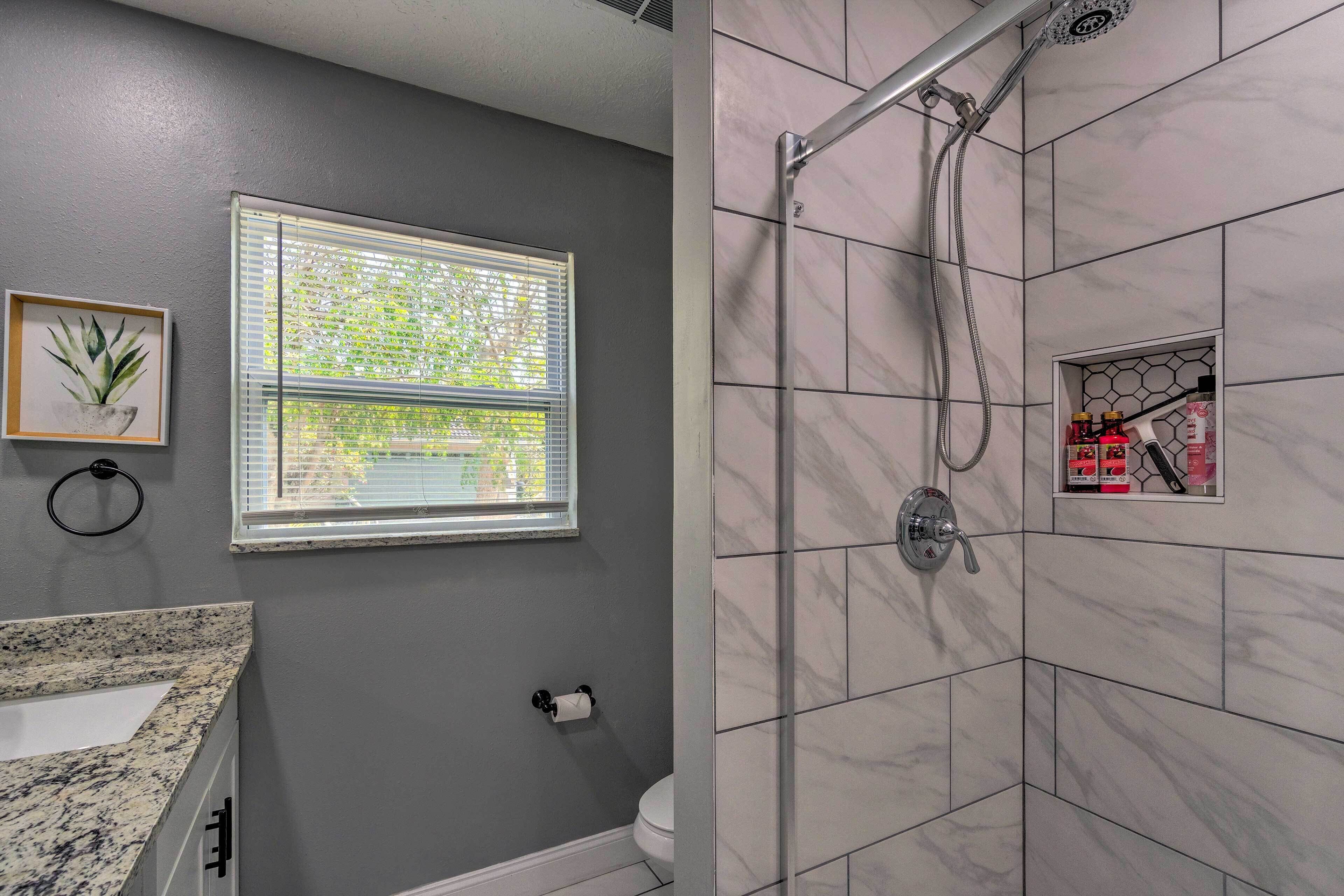 Une salle de bain avec une fenêtre, une douche et des toilettes.