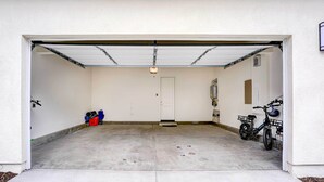A garage with a white door, a bicycle, and a red toolbox. - 4 Mi to Beach! San Juan Capistrano Home w/ Patio (San Juan Capistrano)