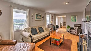 A spacious living room with a sofa, armchairs, a coffee table, and a fireplace. - Queen City Home w/ Ohio River View - 3 Mi to Dtwn! (Cincinnati)