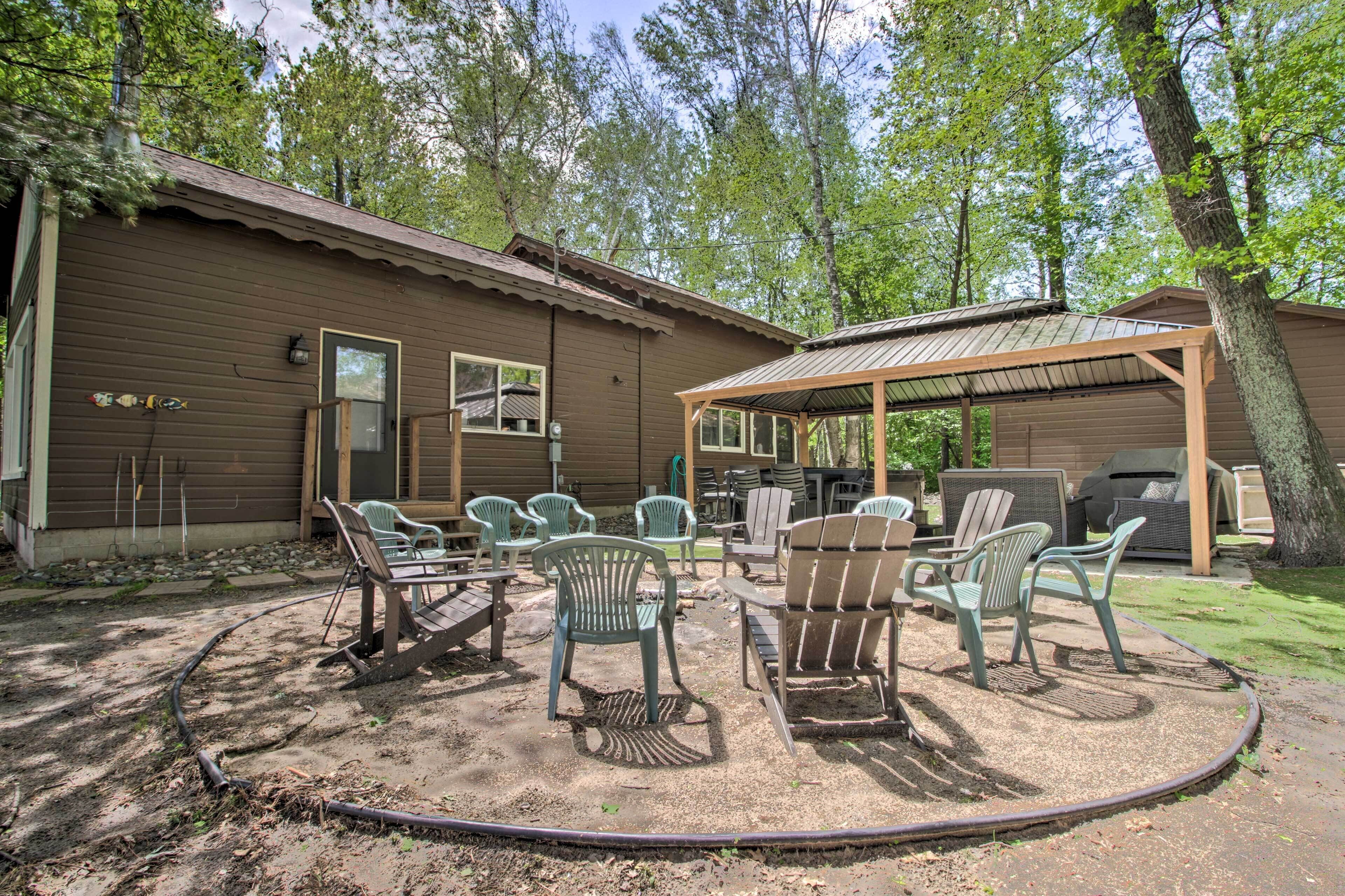 A rustic cabin with a covered patio area, outdoor seating, and a grill.