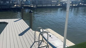 A wooden dock with a metal lifebuoy and a kayak. - Matlacha Waterfront Retreat: Dock & Hot Tub! (Matlacha)