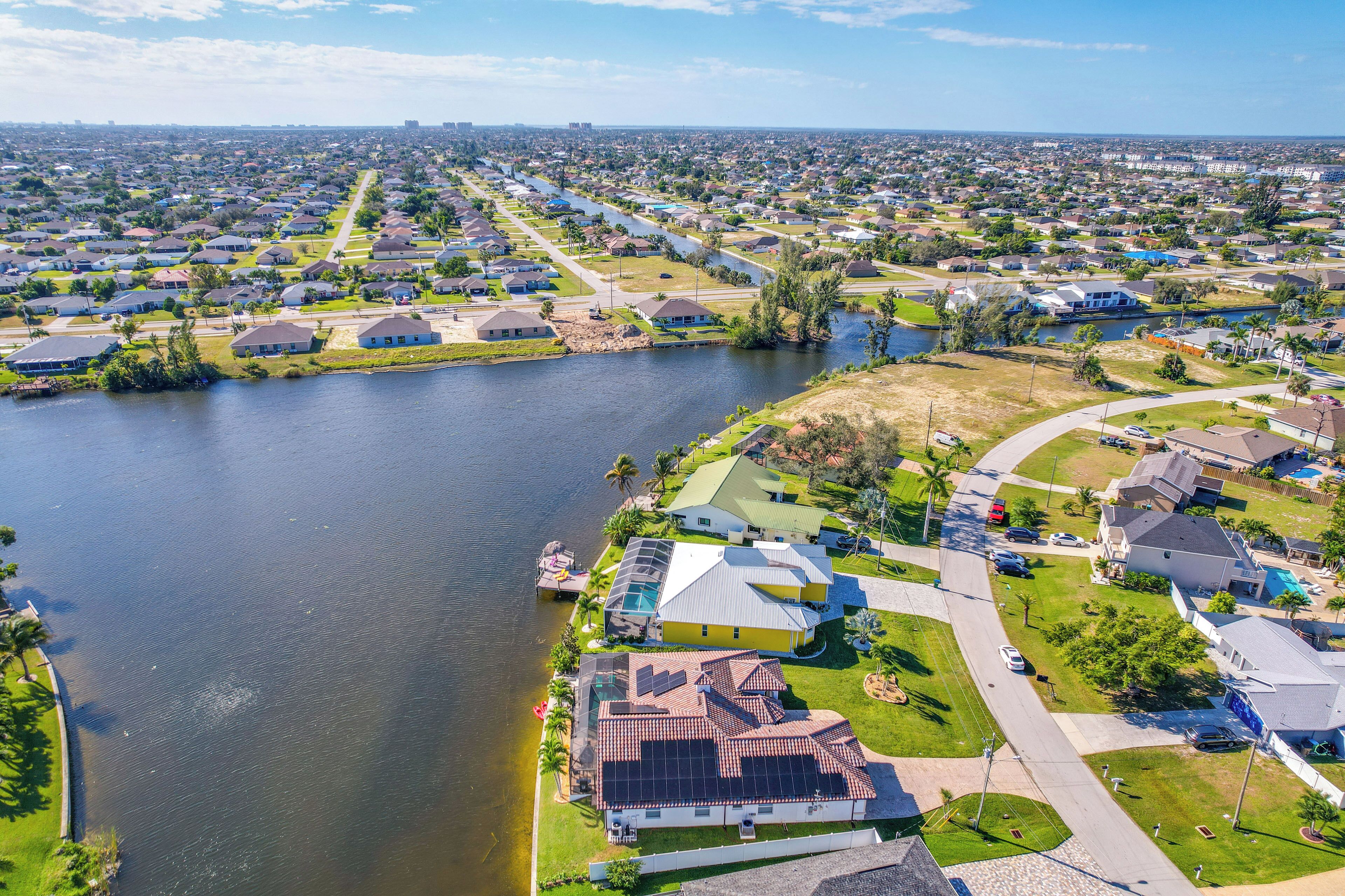 A residential area with houses along a river, a central road, and a park with a playground.