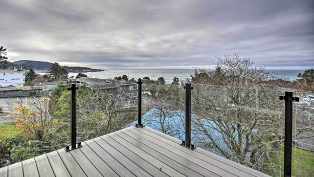 A view from a deck overlooking a body of water with buildings in the background. - Scenic Depoe Bay Townhome w/ Deck < 1 Mi to Parks! (Depoe Bay)