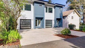 A modern two-story house with a garage, driveway, and landscaped garden. - Scenic Depoe Bay Townhome w/ Deck < 1 Mi to Parks! (Depoe Bay)