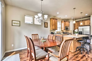 A spacious kitchen with wooden cabinets, a central island, and a dining area with chairs.