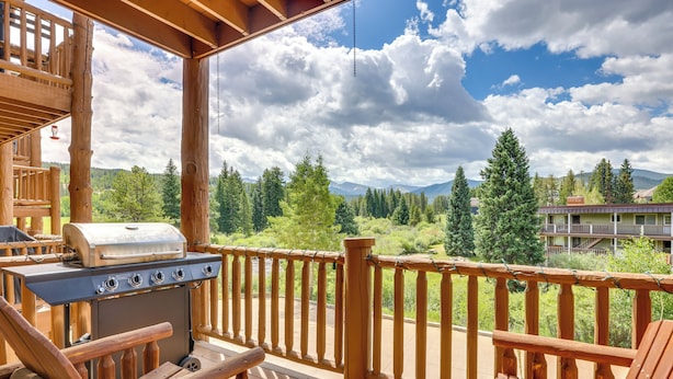 A wooden deck with a grill and seating area overlooking a forested landscape. - Cozy Condo w/ Views, 3 Mi to Winter Park Resort! (Winter Park)