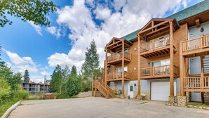 A multi-story wooden building with balconies, a garage, and a stone foundation. - Cozy Condo w/ Views, 3 Mi to Winter Park Resort! (Winter Park)