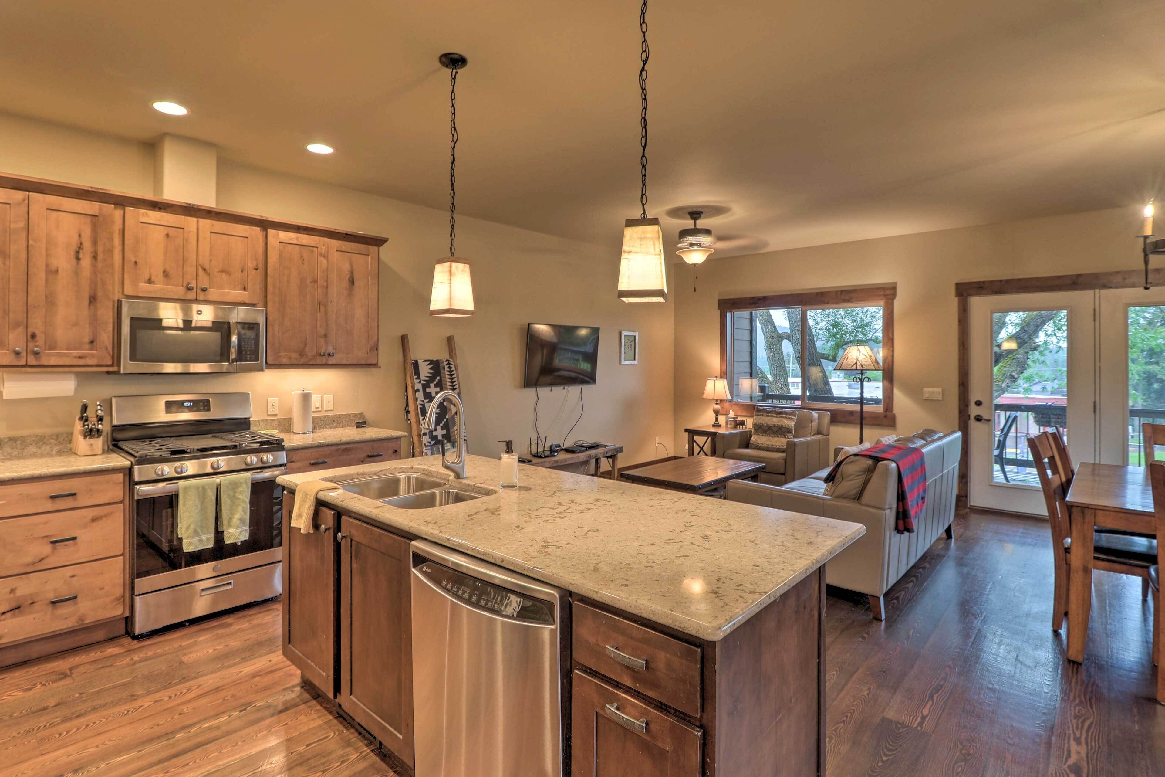 A modern kitchen with wooden cabinets, stainless steel appliances, and a granite countertop.