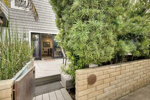 A modern house with a covered patio, a brick wall, and a variety of plants. - San Diego Home w/ Deck: Walk to Mission Beach! (San Diego)