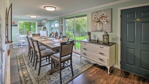 Un espace repas comprenant une longue table, des chaises et un vase décoratif.