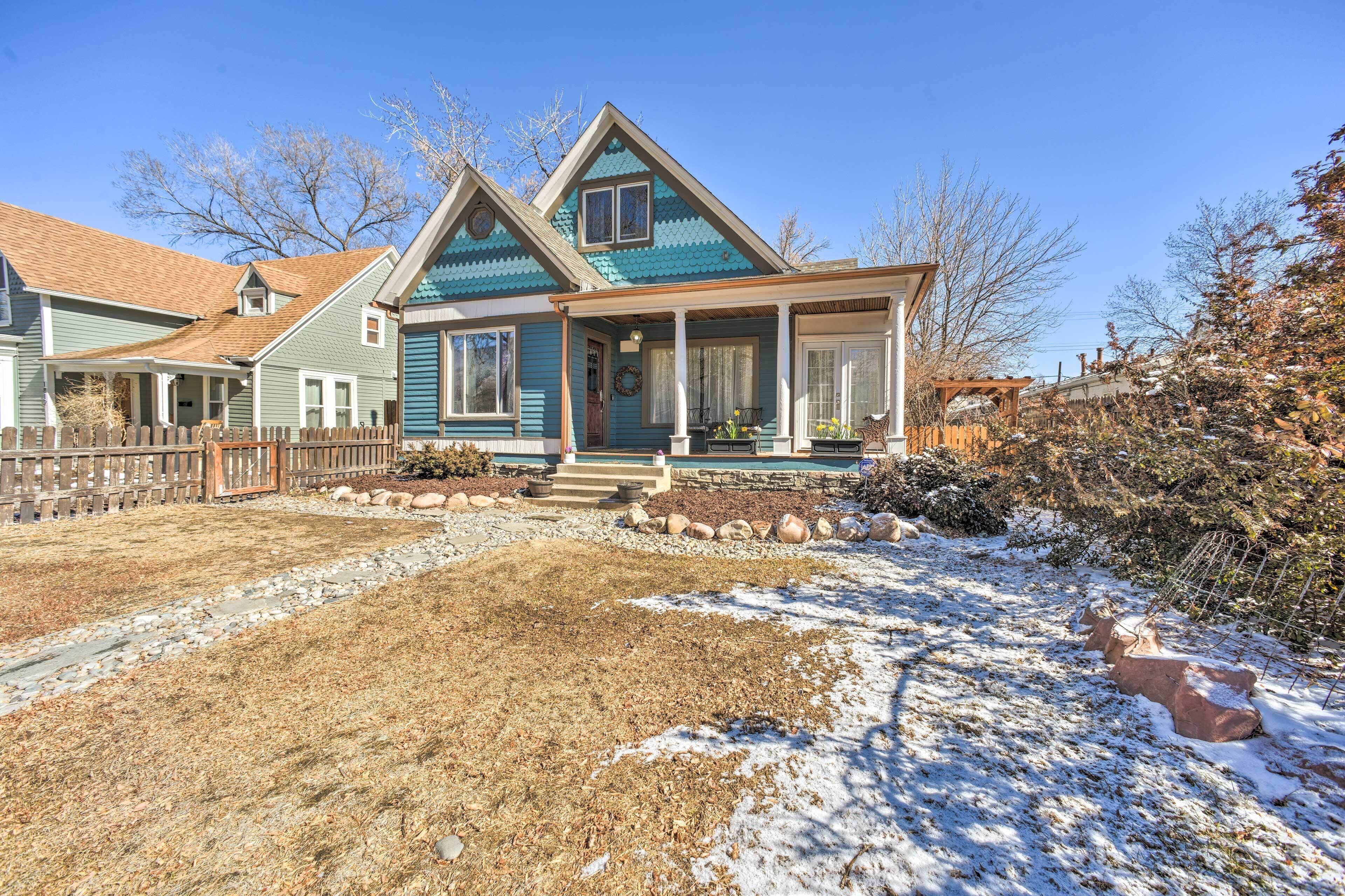 A two-story house with a porch, a front yard with a stone pathway, and a snow-covered ground.