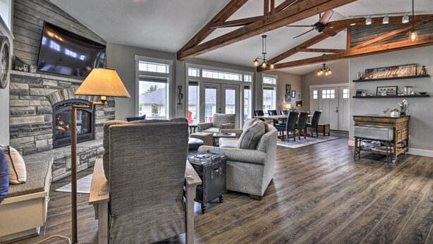 A spacious living room with a stone fireplace, comfortable seating, and a dining area with a view. - 'traveler's Retreat' Studio w/ Patio & Yard! (Tualatin)
