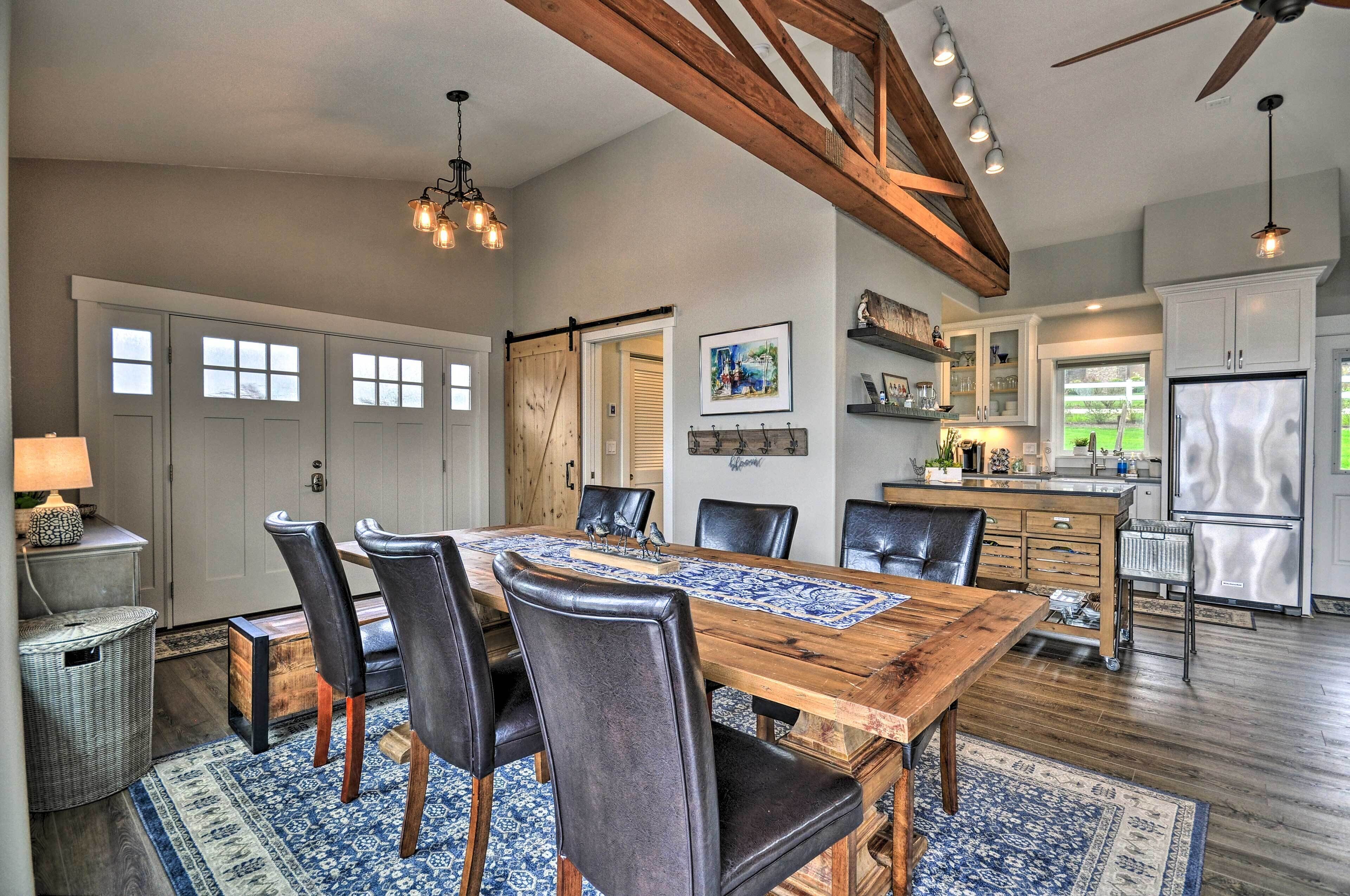 A spacious kitchen with a large island, wooden cabinets, and a stainless steel refrigerator.