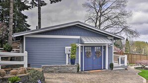 A modern two-story house with a blue exterior, a front porch, and a driveway leading to the entrance. - 'traveler's Retreat' Studio w/ Patio & Yard! (Tualatin)