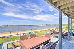 A wooden deck with wicker furniture overlooking a body of water with boats. - Bayfront Wareham Retreat w/ Private Beach! (Wareham)