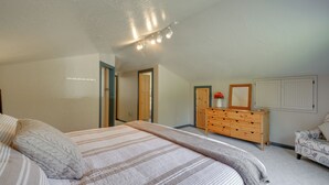 Une chambre à coucher avec un lit, une commode et un miroir.
