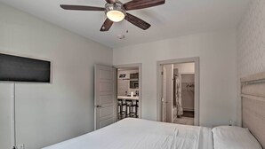 A bedroom with a bed, a ceiling fan, and a view into the kitchen area. - Modern Nashville Condo: 7 Mi to Downtown! (Nashville)