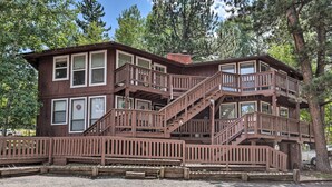 A multi-story wooden cabin with a balcony and stairs, surrounded by trees. - Angel Fire Mountainside Condo < 1/2 Mi to Slopes (Angel Fire)