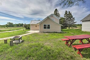 A small, single-story house with a front porch and a picnic table in the yard. - Quiet Baileys Harbor Country Home: 1 Mi to Lake! (Baileys Harbor)