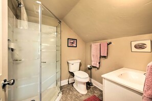 A bathroom with a glass shower enclosure, a toilet, a sink, and two towels hanging on the wall. - Quiet Baileys Harbor Country Home: 1 Mi to Lake! (Baileys Harbor)