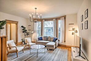 A cozy living room with a sectional sofa, a round coffee table, and a chandelier. - Cozy Eclectic Home ~ 1 Mi to Downtown Spokane (Spokane)