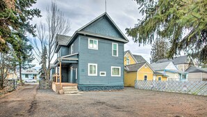 A two-story house with a front porch, a driveway, and a fenced yard. - Cozy Eclectic Home ~ 1 Mi to Downtown Spokane (Spokane)