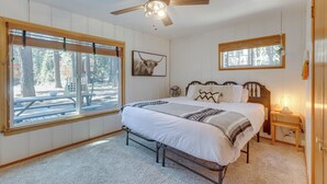 A bedroom with a bed, a ceiling fan, a bedside table with a lamp, and a window with blinds. - Tahoe Home in the Pines: Quiet Neighborhood! (South Lake Tahoe)