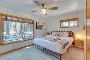 A bedroom with a bed, a ceiling fan, a bedside table with a lamp, and a window with blinds. - Tahoe Home in the Pines: Quiet Neighborhood! (South Lake Tahoe)
