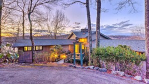 Une cabane rustique avec une façade en bois, une véranda et un escalier menant à l’entrée.