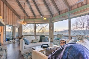 A cozy, well-lit room with a wooden ceiling, large windows, and comfortable seating. - Brevard Home w/ Panoramic Lake & Mountain Views! (Brevard)