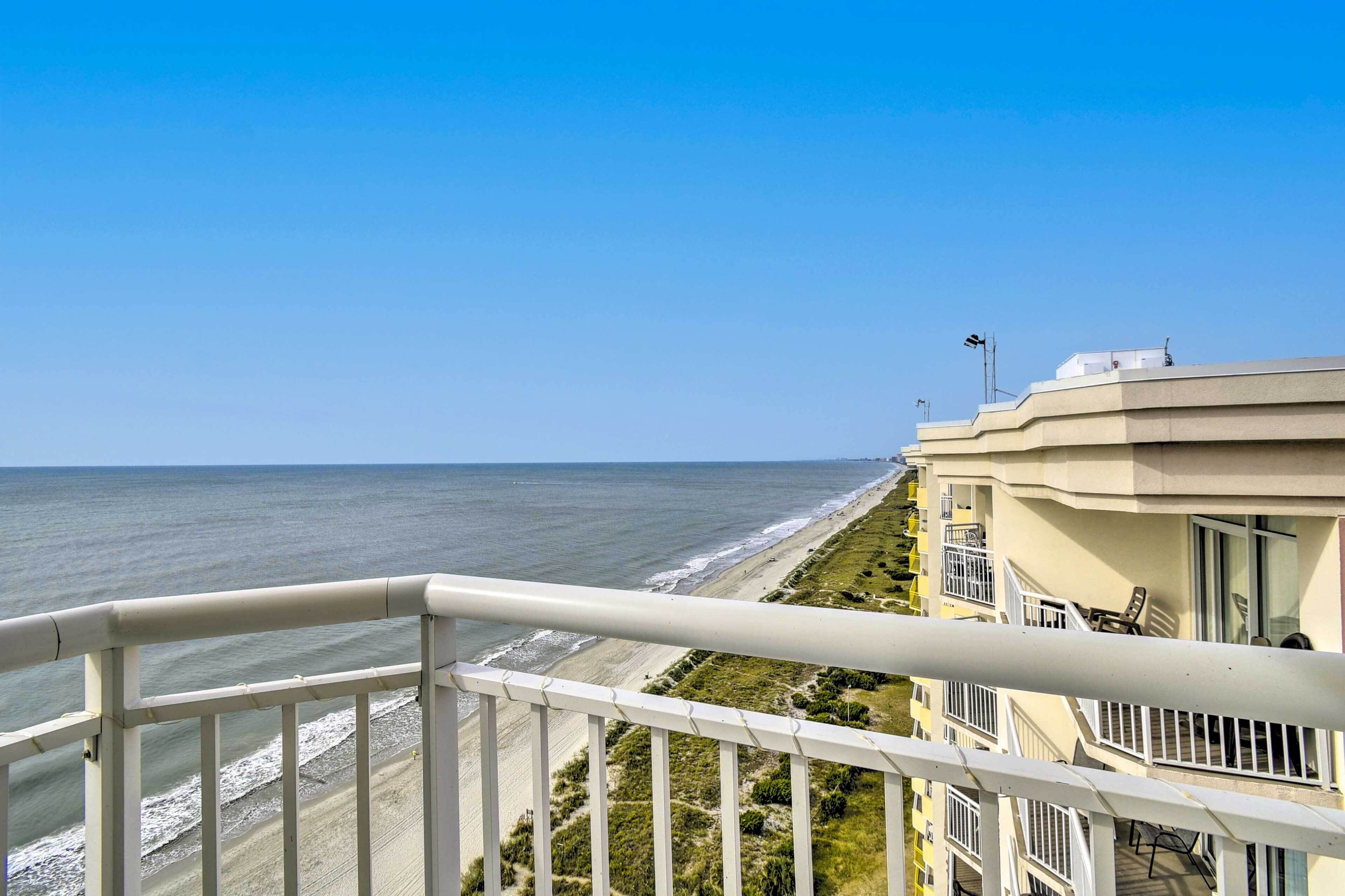 A balcony with a view of the beach and ocean.