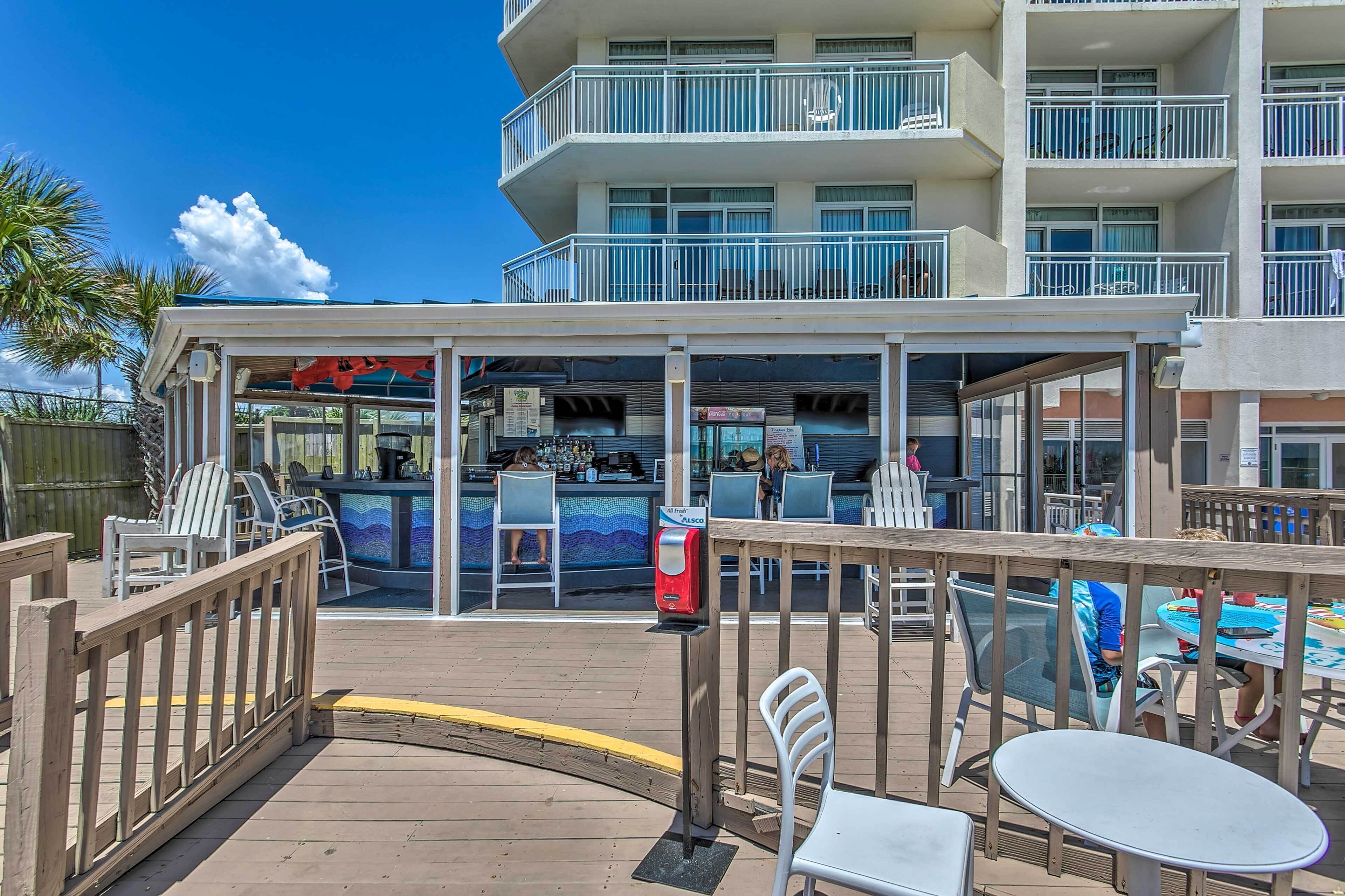 Ein Restaurant direkt am Strand mit Außenbereich, einer Poolbar und Blick auf den Ozean.