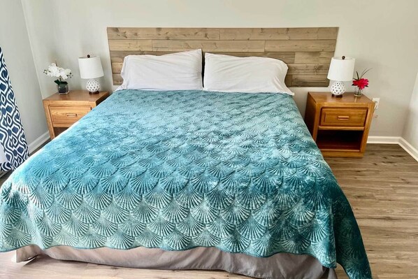 A bed with a blue patterned bedspread, two white pillows, and a wooden headboard. - Hike, Ski, Explore: Lincoln Condo w/ Pool Access (Lincoln)