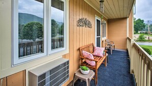A wooden porch with a bench and chairs, a small table with a potted plant, and a decorative wall piece. - Hike, Ski, Explore: Lincoln Condo w/ Pool Access (Lincoln)