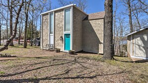 A single-story house with a blue door, surrounded by trees and a gravel driveway. - Lake View! Family Resort Retreat in Osage Beach (Osage Beach)