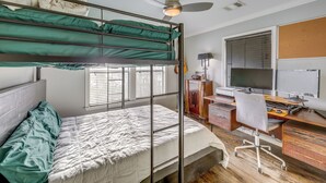 A dorm-style room with bunk beds, a desk with a computer, and a guitar. - Pet-friendly Austin Home w/ Private Yard + Deck! (Austin)