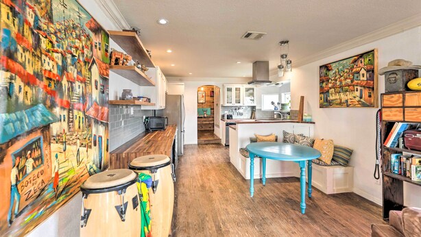 A spacious kitchen with wooden floors, a central island, and a dining area with a blue table. - Pet-friendly Austin Home w/ Private Yard + Deck! (Austin)