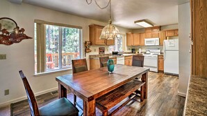 A spacious kitchen with wooden cabinets, a dining table, and a large window. - 4 Mi to Heavenly: Home w/ Deck in South Lake Tahoe (South Lake Tahoe)