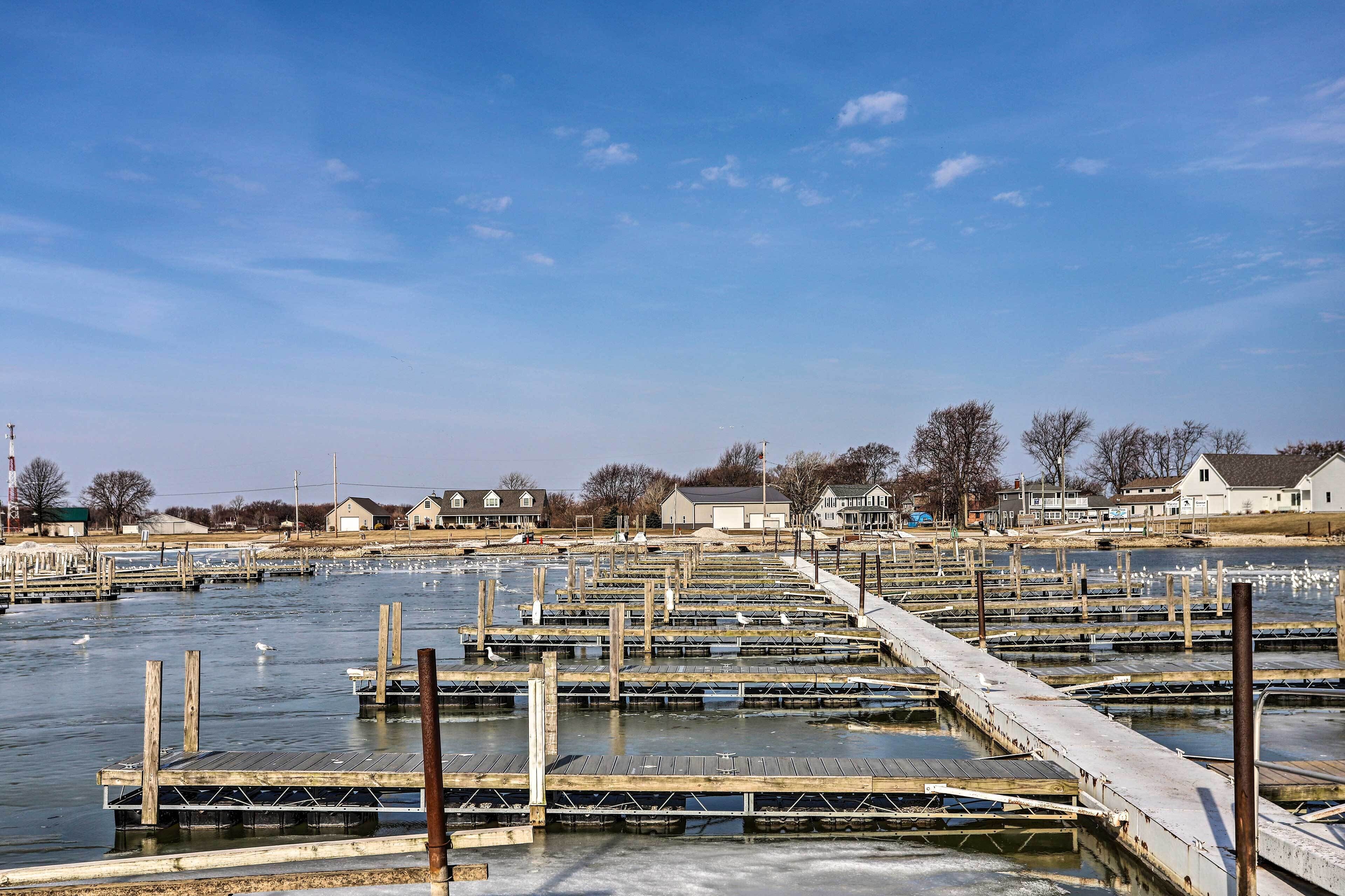 Un port de plaisance avec des quais en bois et des bateaux, entouré de maisons et d’arbres.