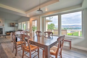 Un vaste espace dédié à la salle à manger, avec une grande table et des chaises en bois, une cheminée et un téléviseur.